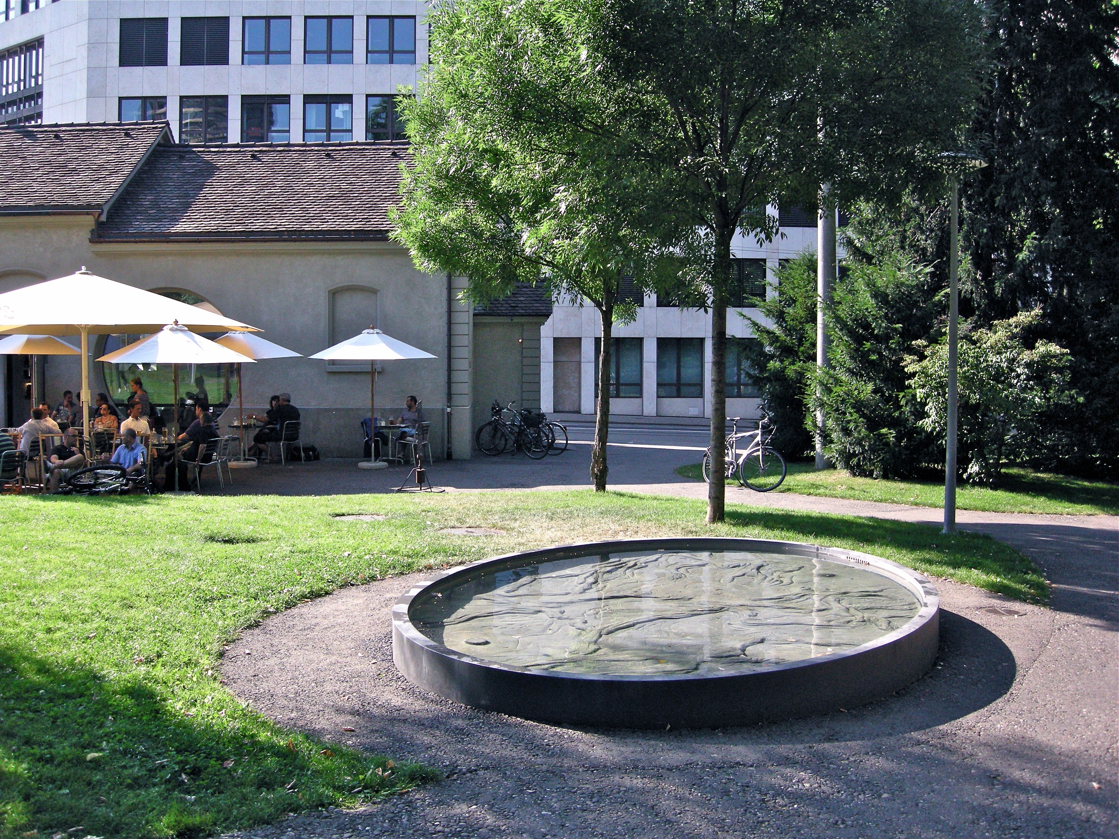 Fountain with relief in concrete, 2008. In the background Caffè Kultur Bar 'Zum Kuss'. Elisabethenpark, Basel.